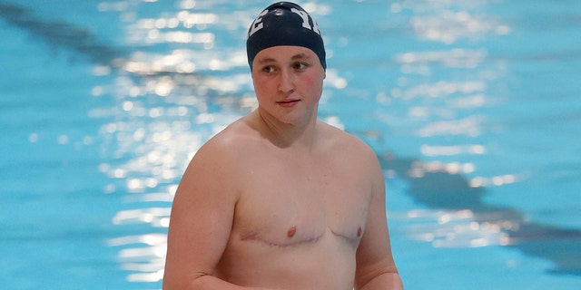 Iszac Henig of Yale stands on the pool deck before preparing for an event at the Ivy League Women's Swimming and Diving Championships at Harvard University, Thursday, Feb. 17, 2022, in Cambridge, Massachusetts.  Starting hormonal treatments so far, she's swimming for the Yale Women's team.